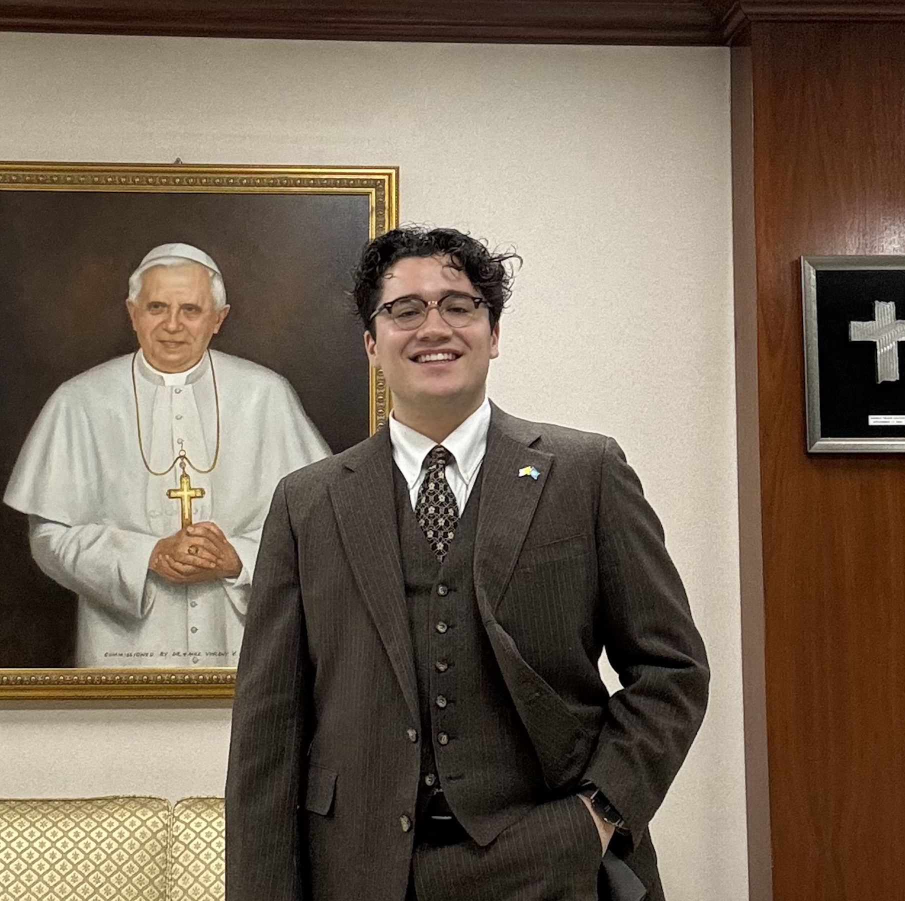 Student standing in front of mural